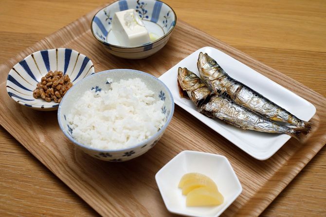 木製トレーに載せられた、焼き魚、白米、納豆、冷奴、たくあんの和食セット