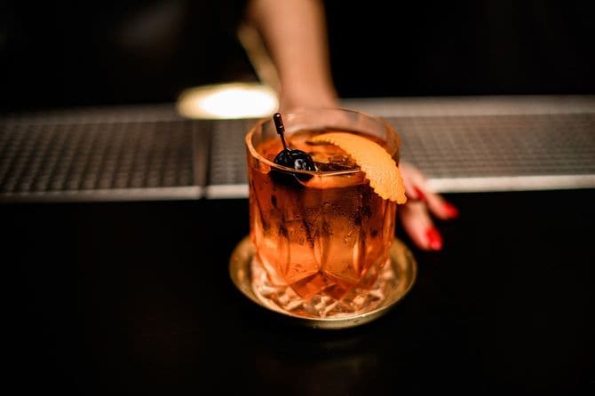 出来上がったアルコールカクテルを差し出す女性の手元