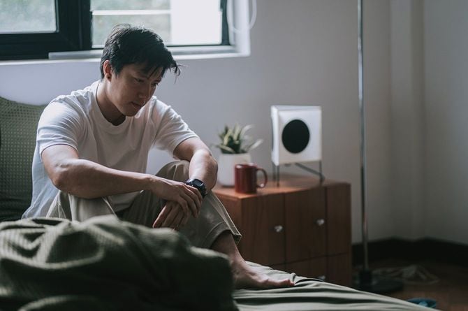 ベッドに座っている悲しそうな男性