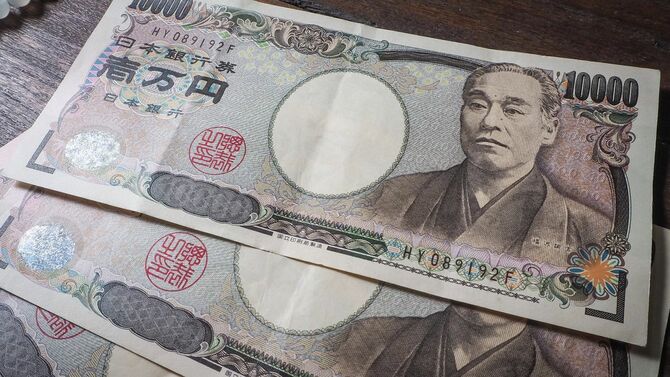 机の上に3枚の1万円札