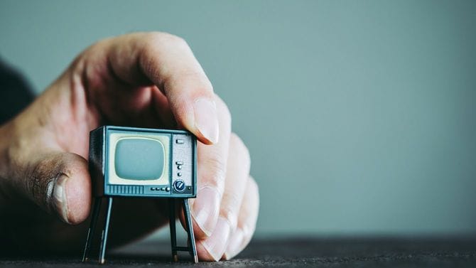 男性の手の中にテレビ