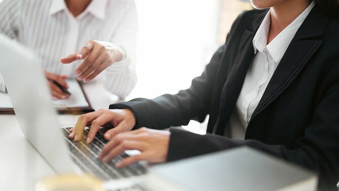 上司の指示をパソコンに入力している女性