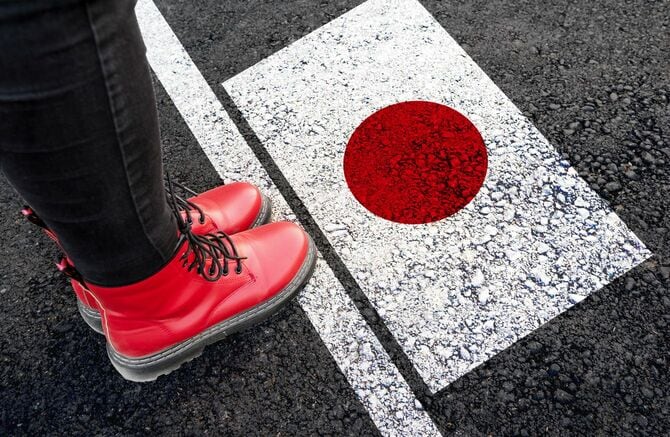 地面に描かれた日本の国旗のそばに立つ女性