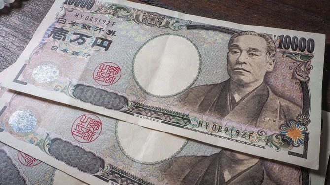 机の上に3枚の1万円札