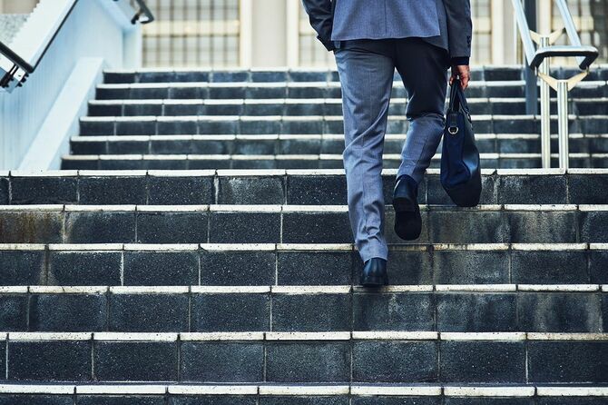 階段を上るスーツの男性
