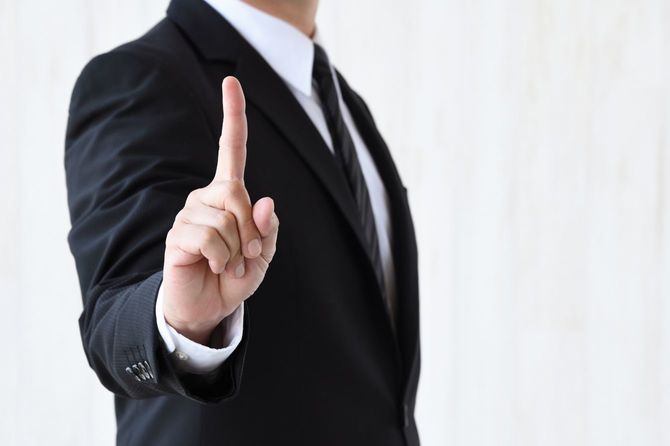 人差し指を立てるビジネスマン