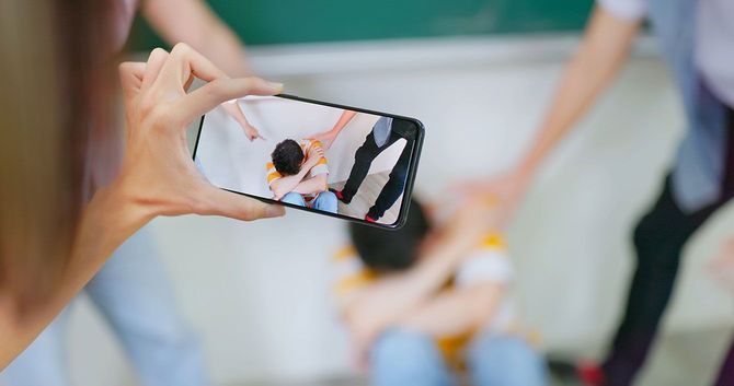 いじめの様子をスマホで撮影する子供