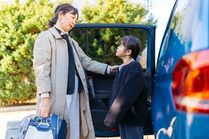 娘を学校に連れて行く働く母親