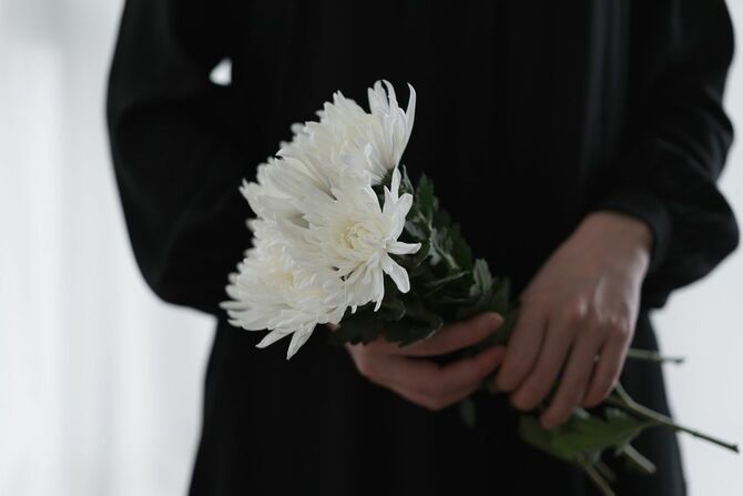 菊の花を手に持つ女性