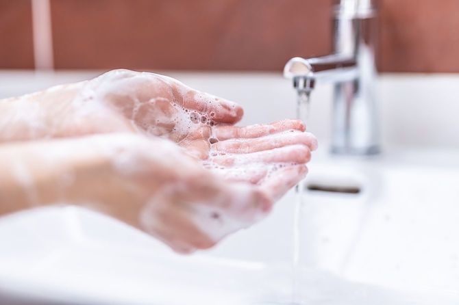 洗面所で水と液体石鹸で手洗い