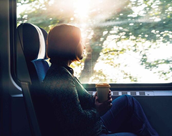 電車の窓のそばに座る女性