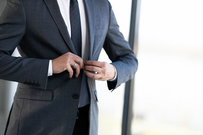 スーツのジャケットのボタンを留めるビジネスマン