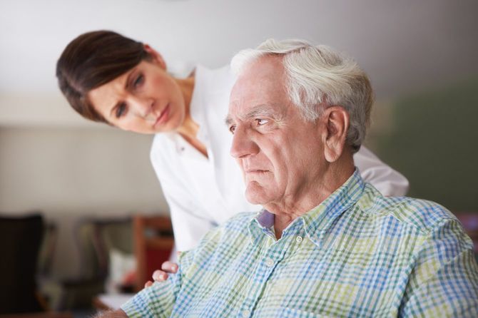 心を閉ざしがちなシニア男性を心配する介護士