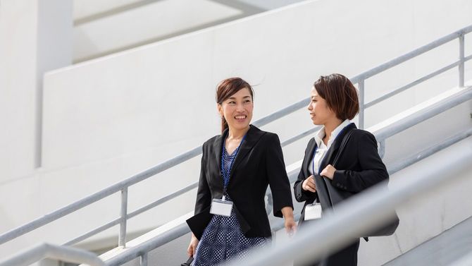 歩きながら会話する2人のビジネスウーマン