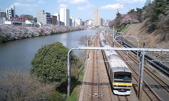 中央・総武線各駅停車、飯田橋～市ヶ谷間で撮影。外堀の桜が開花。（写真＝CC-BY-SA-3.0／Wikimedia Commons）