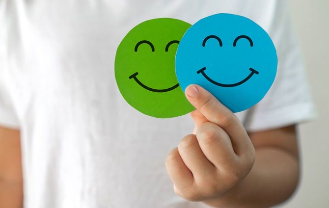 スマイルマークを二つ手に持つ人の手元