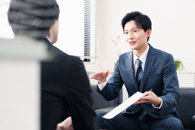 顧客と話をする営業の男性