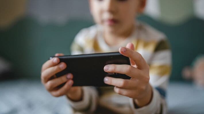 スマホでゲームをする子供