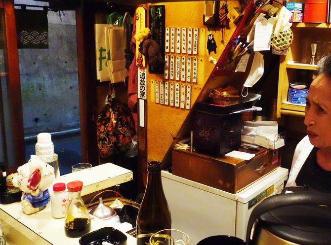 「串木乃」の店内とカウンターに立つママ