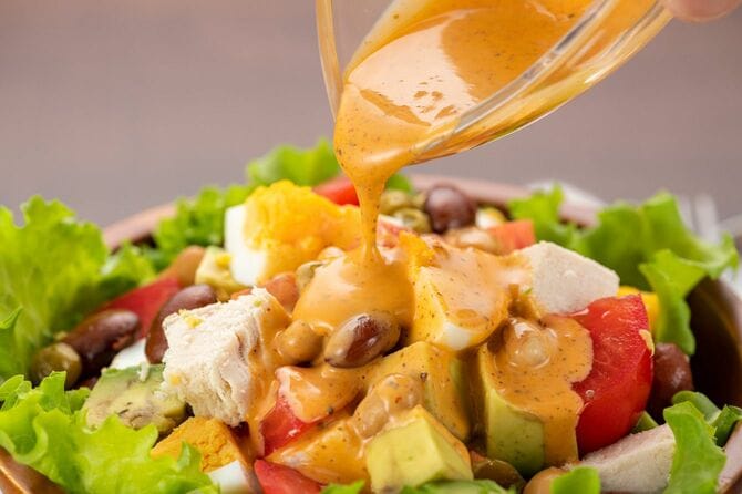 ドレッシングを注がれるコブサラダ