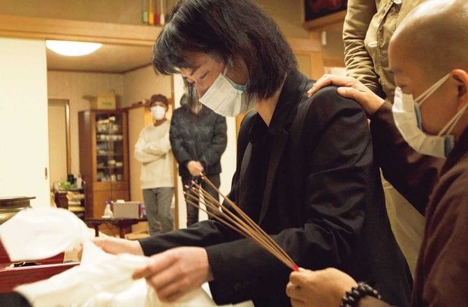 大恩寺に幼馴染みの遺骨を持ってきたホアさん。在日ベトナム仏教信者会会長の尼僧ティック・タム・チーさんが優しく肩に手を置いた途端、大粒の涙が流れた。(筆者撮影)