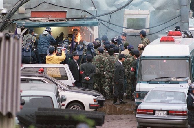 家宅捜索でエンジンカッターなどを使って第6サティアンの扉をこじ開けて中に入る捜査員＝1995年5月16日、山梨・上九一色村）