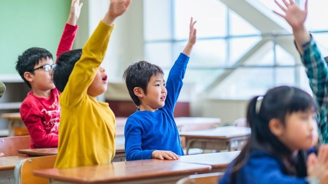 教室内で、挙手する子供たち