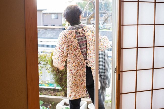 冬の晴れた日に洗濯物を干すシニア女性