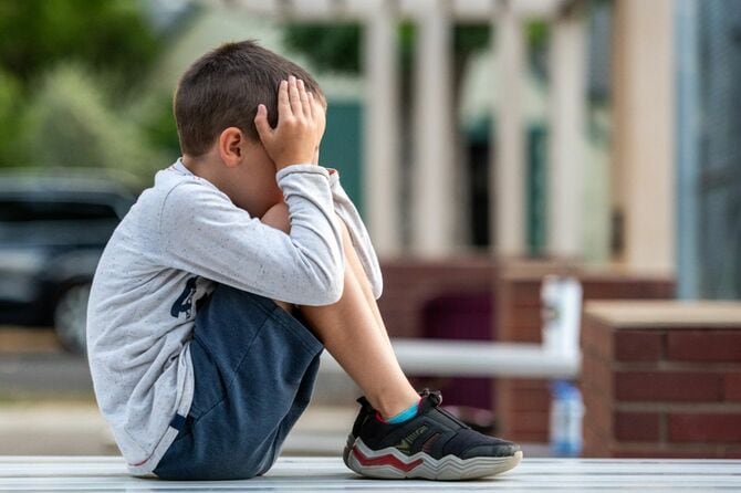 顔を手で覆って泣いている男の子