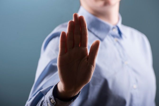 手のひらをこちらに向けて拒否を示す人