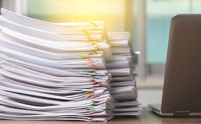 ノートパソコンとあまりにも大量なリポート用紙