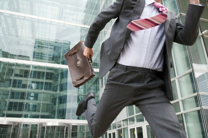 オフィスから外に走るビジネスマン