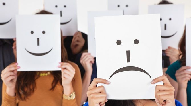 不幸せな悲しい顔のサインを持つ女性幸せな人々に囲まれています。