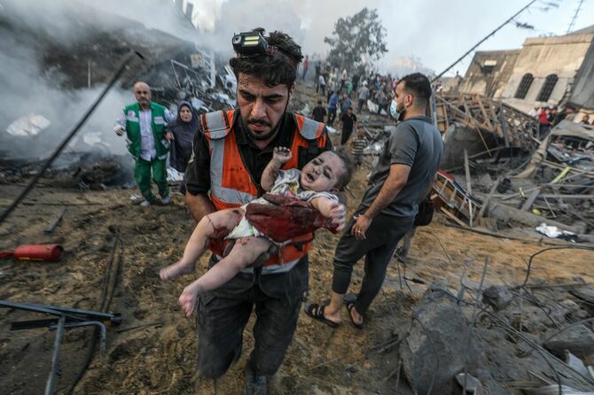 負傷した赤ん坊を運ぶパレスチナ人男性