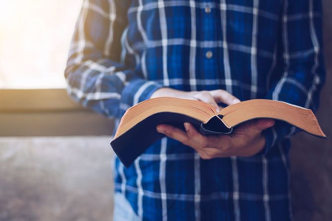 若いクリスチャン男性読書聖書