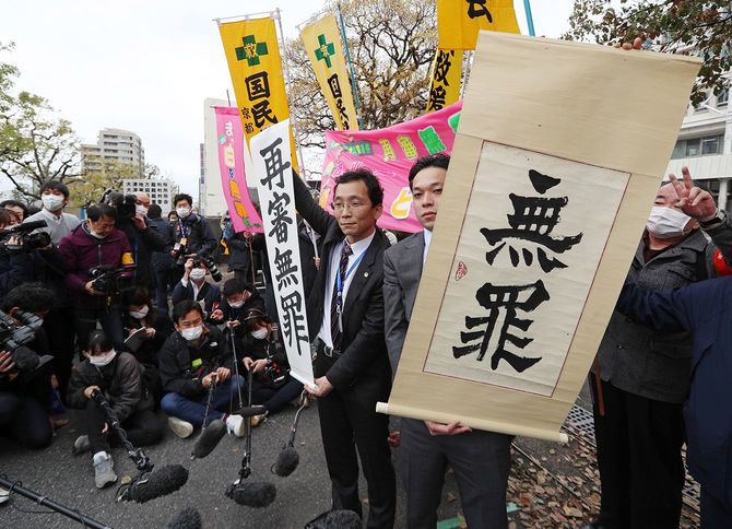 西山美香さんの再審判決で無罪が言い渡され、垂れ幕を掲げる弁護士
