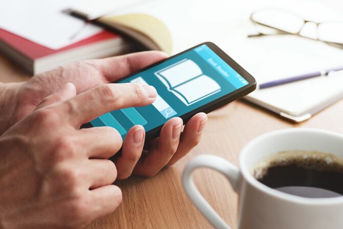 スマートフォンでオンラインブックリーダーアプリ内を検索している人の手元