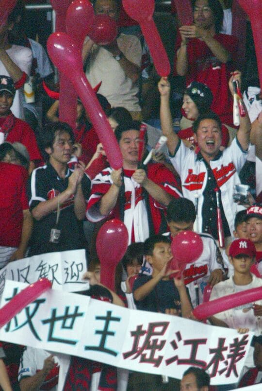 2004年7月、近鉄ファンに囲まれ、試合を観戦するライブドアの堀江貴文社長（中央）＝大阪ドーム