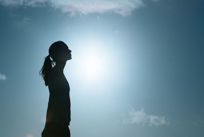 空を見上げる女性のシルエット