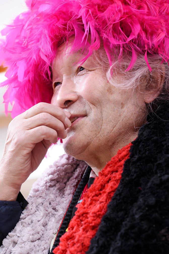 ピンクアフロのカツラで話す男性