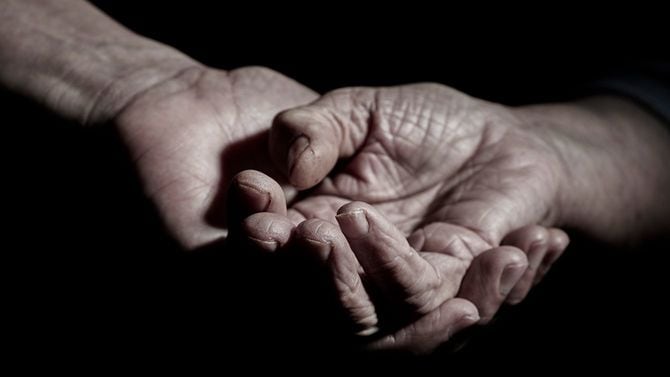 年配女性の手を握る男性の手