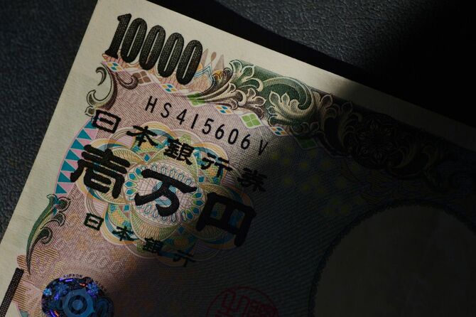 暗い部屋で、光が当たっている一万円紙幣