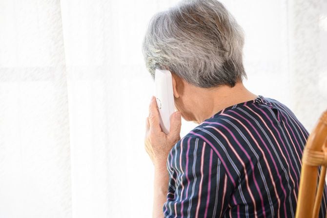 電話で話す年配の女性