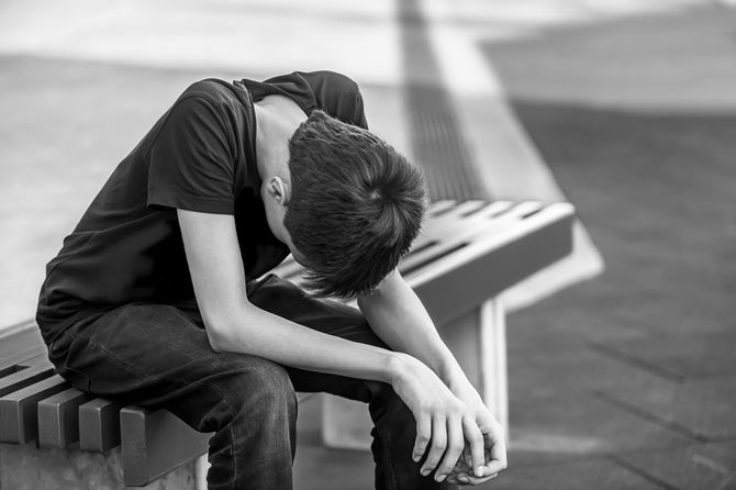 ベンチに座っている悲しそうな男性