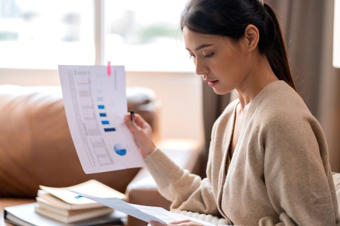 自宅で書類をチェックする女性