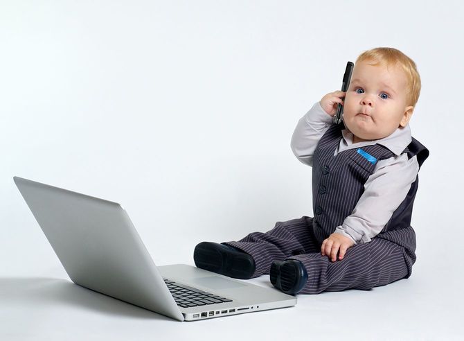 携帯電話を耳にあてる赤ちゃん