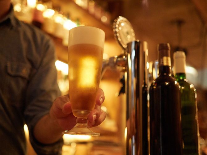 グラスに生ビールを注ぐバーテンダー