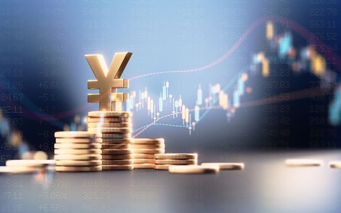 積み重ねて置かれたコインの上に日本円のマーク、背景は為替チャート