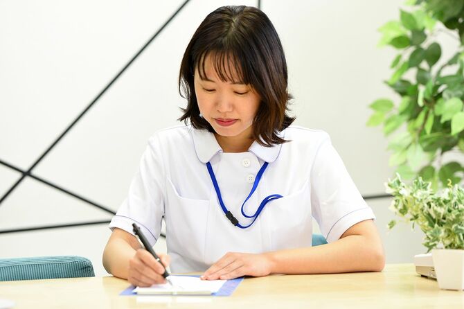 メモを書くアジアの若い女性医療従事者
