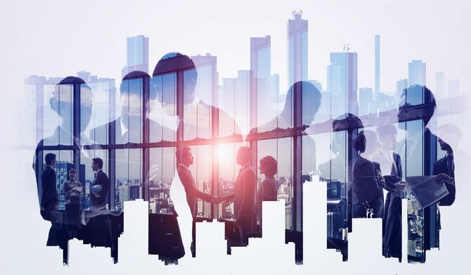 ビジネスマンの働く姿の背景に大都市のビル群